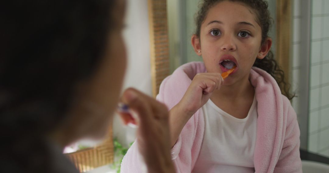 Young Girl Practicing Oral Hygiene by Brushing Teeth in Bathroom Mirror - Free Images, Stock Photos and Pictures on Pikwizard.com