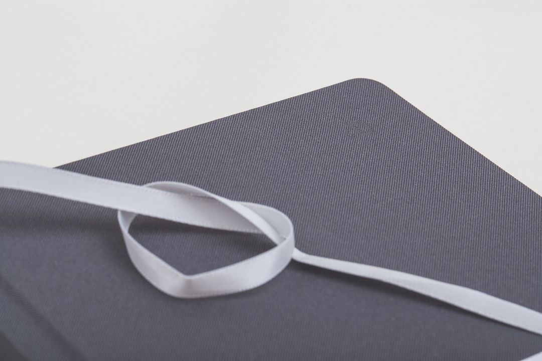 Elegant Gray Book Wrapped in White Ribbon on White Background - Free Images, Stock Photos and Pictures on Pikwizard.com