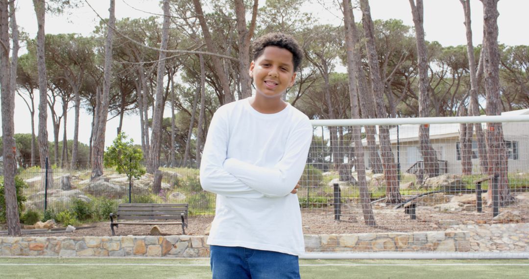 Teen Boy Standing on Soccer Field with Goal Net in Background
