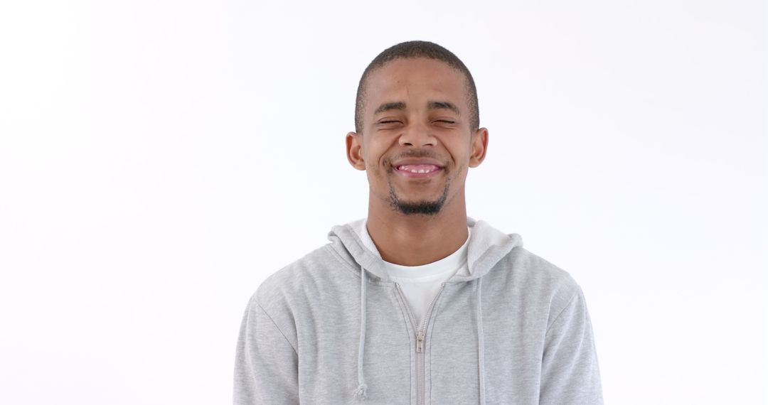 Smiling Man in Gray Hoodie Exuding Confidence and Happiness