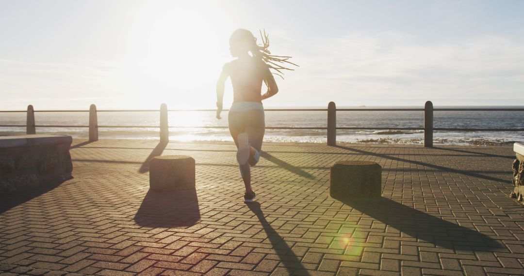 Woman Jogging Along Seaside at Sunrise with Clear Sky - Free Images, Stock Photos and Pictures on Pikwizard.com