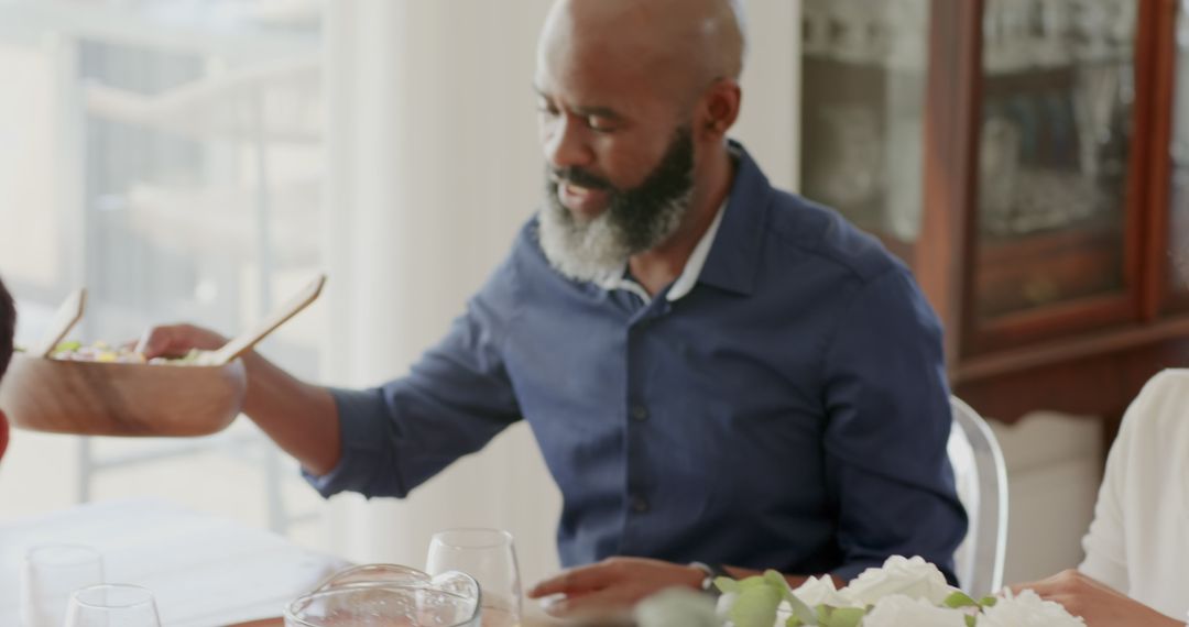 Man enjoying family meal at dining table with shared desserts