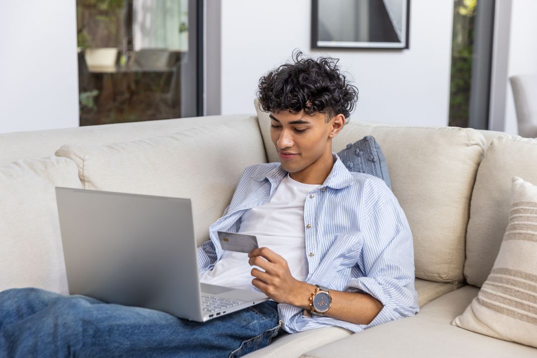 Young Man Enjoying Online Shopping from Comfortable Sofa at Home