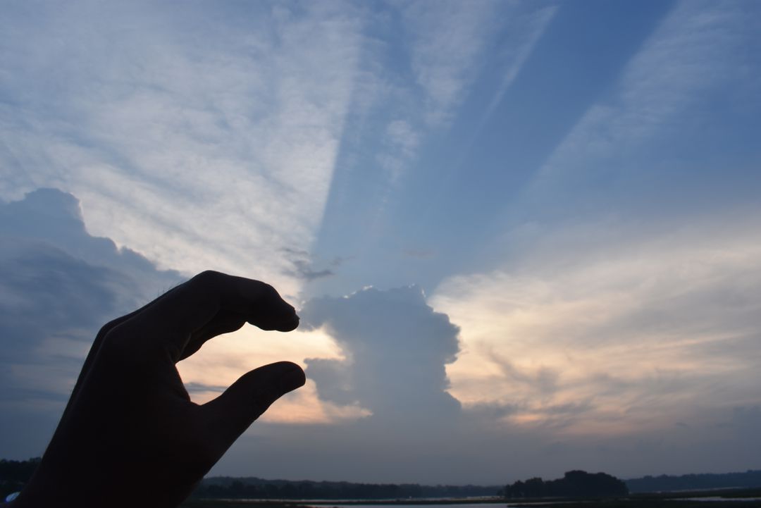 Hand Silhouette Holding Cloud at Sunset - Free Images, Stock Photos and Pictures on Pikwizard.com