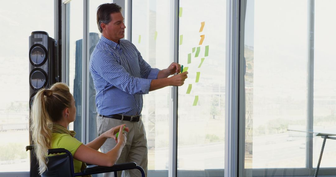Colleagues Collaborating on Project with Sticky Notes in Bright Office