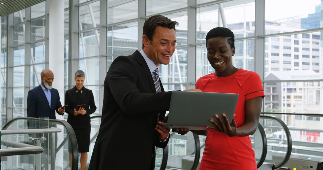 Diverse Professionals Collaborating with Laptops in Modern Office