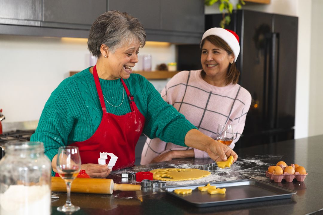 Smiling Mother and Daughter Making Holiday Cookies Together in Kitchen