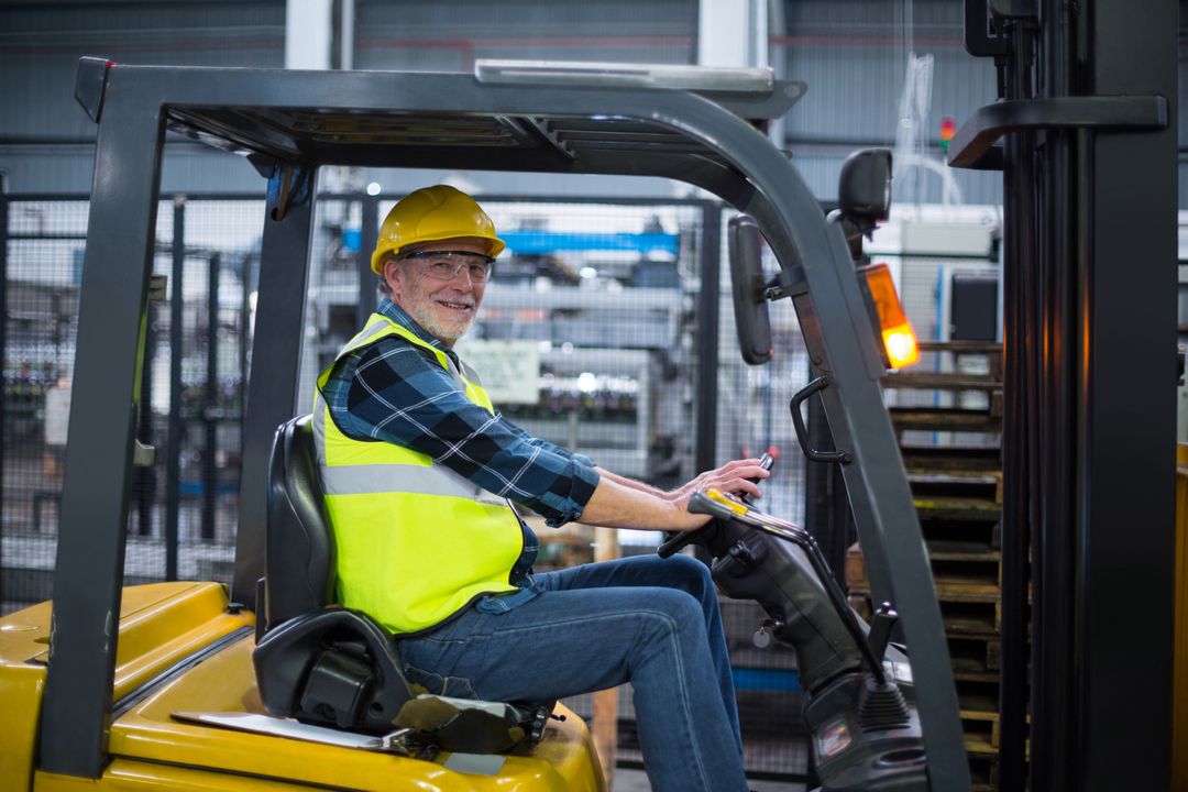 Portrait of smiling factory worker driving forklift - Free Images, Stock Photos and Pictures on Pikwizard.com