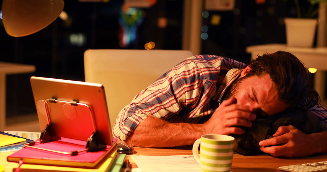 Tired Man Sleeping at Work Desk Late at Night with Tablet and Coffee Mug - Free Images, Stock Photos and Pictures on Pikwizard.com