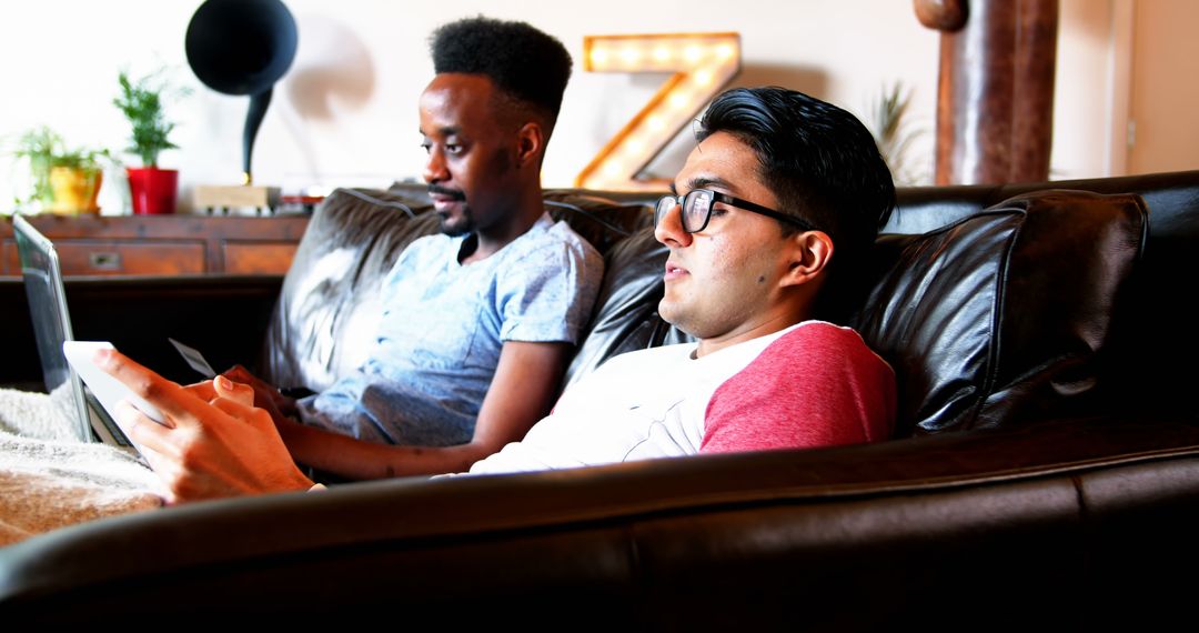 Multiracial Friends Relaxing on Sofa, Using Digital Devices - Free Images, Stock Photos and Pictures on Pikwizard.com