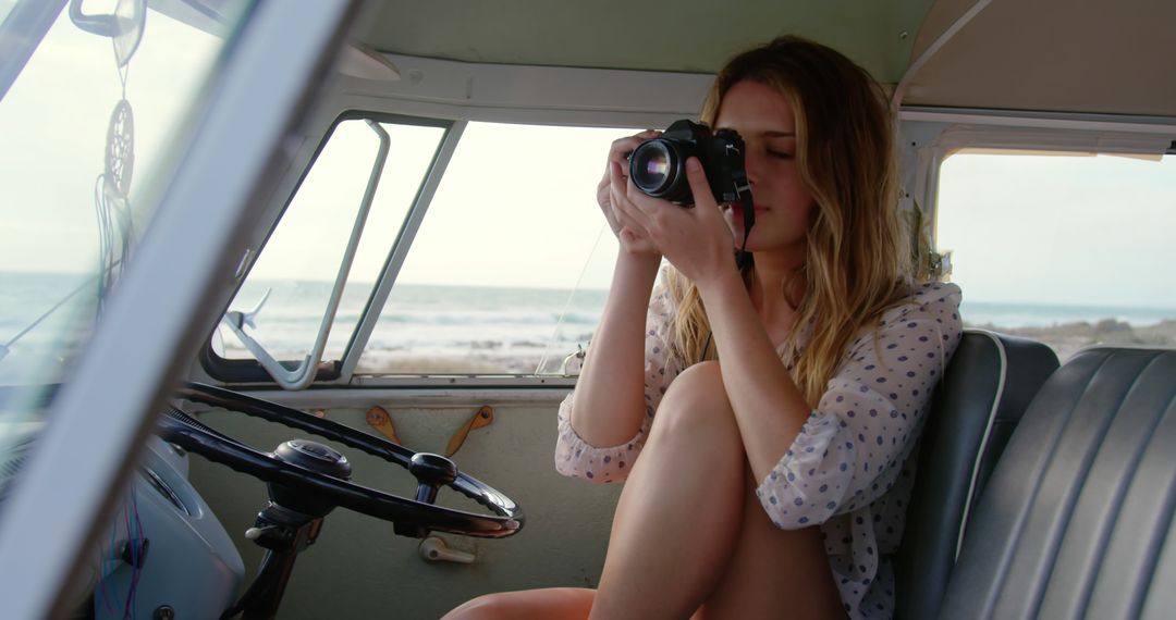 Young Woman Taking Photos on Beach from Camper Van Interior - Free Images, Stock Photos and Pictures on Pikwizard.com