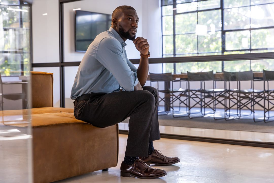 Thoughtful Man Contemplating in Modern Office Wearing Stylish Attire