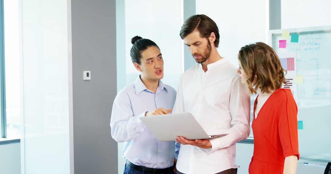 Business Team Collaborating on Laptop Project in Modern Office