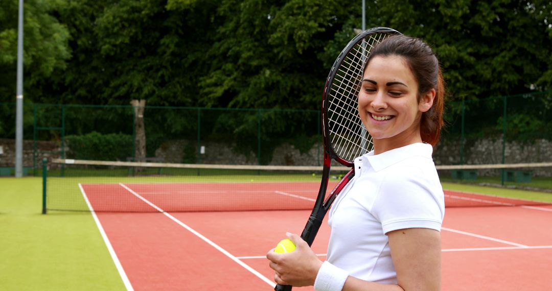 Woman Smiling on Tennis Court Holding Racket and Ball - Free Images, Stock Photos and Pictures on Pikwizard.com