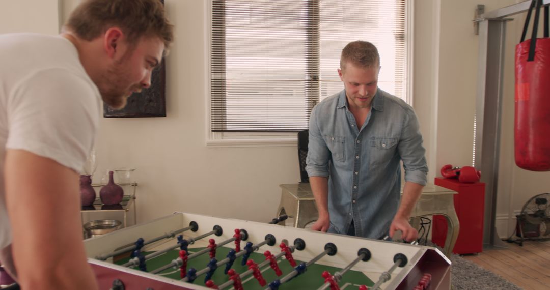 Two Men Relaxing and Playing Foosball at Home - Free Images, Stock Photos and Pictures on Pikwizard.com