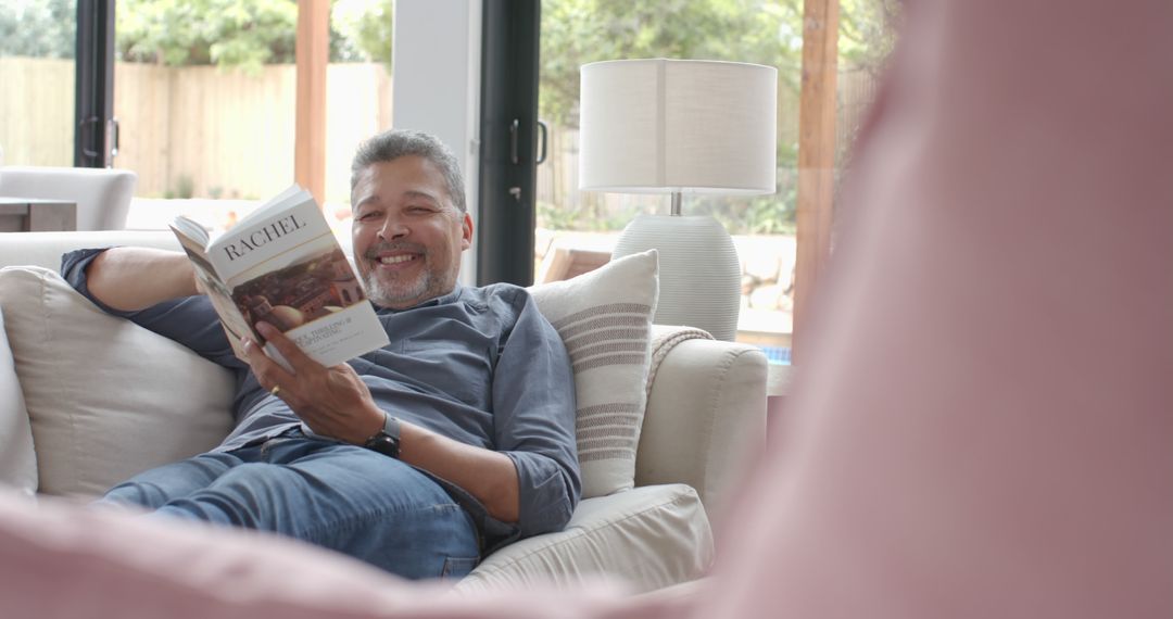 Smiling Senior Man Relaxing on Couch Reading Book at Home - Free Images, Stock Photos and Pictures on Pikwizard.com