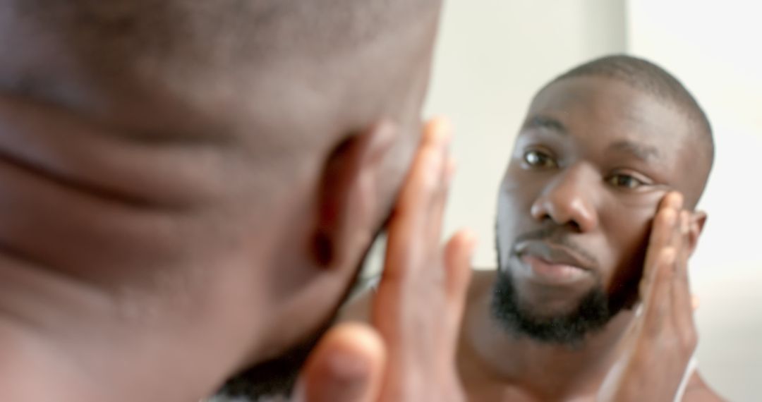 Man Practicing Skincare Routine with Mirror Reflection