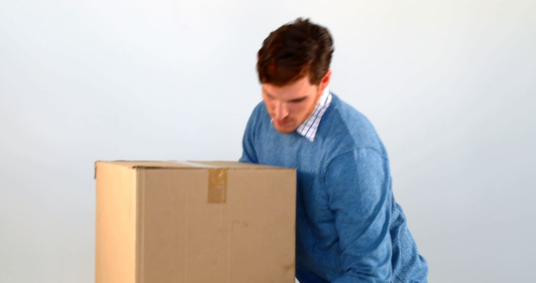 Young Man Lifting Heavy Cardboard Box - Free Images, Stock Photos and Pictures on Pikwizard.com