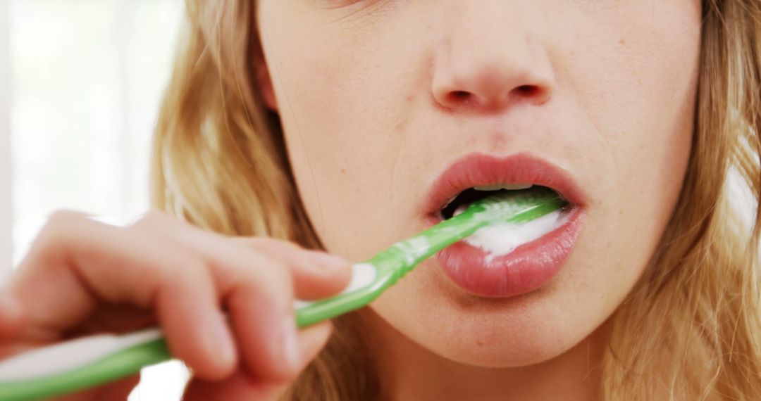 Woman Brushing Teeth with Green Toothbrush - Free Images, Stock Photos and Pictures on Pikwizard.com