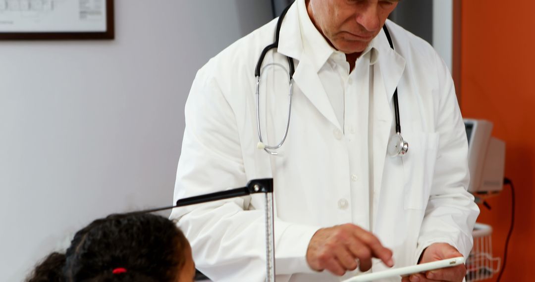 Doctor Using Digital Tablet While Diagnosing Young Patient in Clinic - Free Images, Stock Photos and Pictures on Pikwizard.com