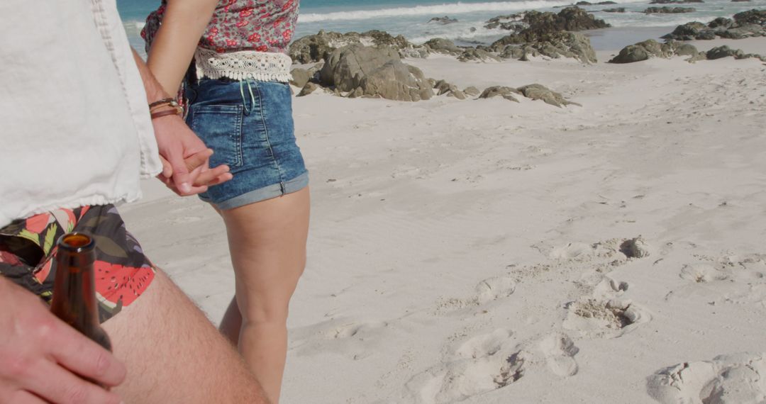Young Caucasian man and biracial woman holding hands on the beach - Free Images, Stock Photos and Pictures on Pikwizard.com
