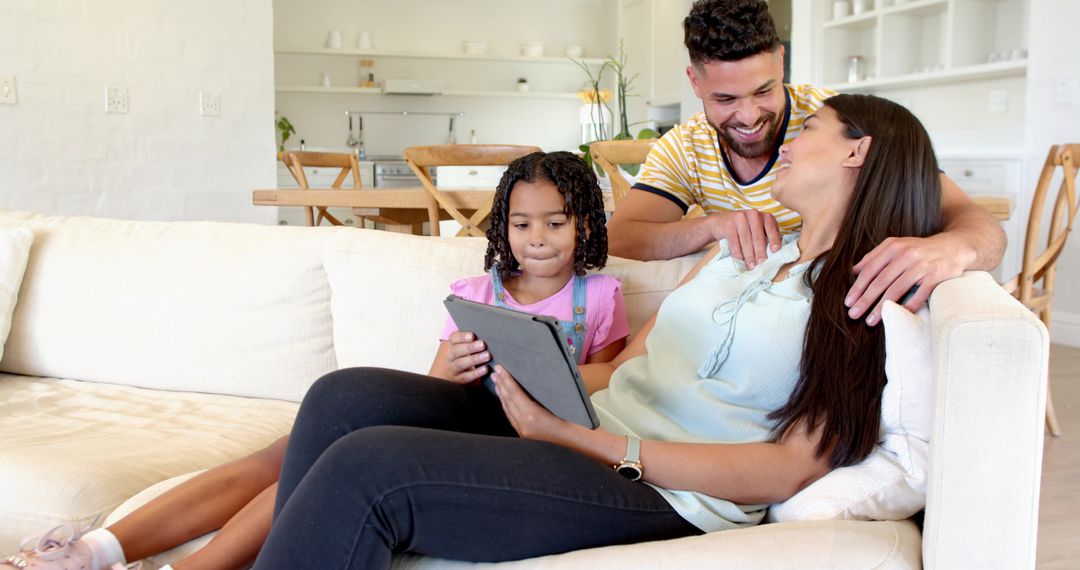 Happy Family Relaxing on Sofa Engaging with Tablet at Home