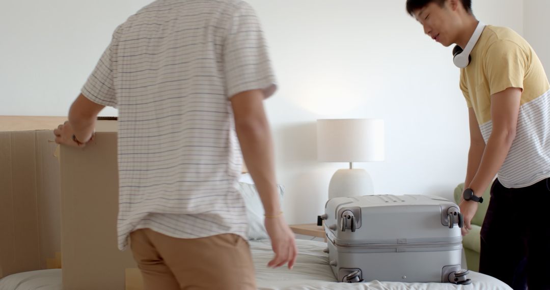 Father and Son Packing Boxes Together in Bright Room