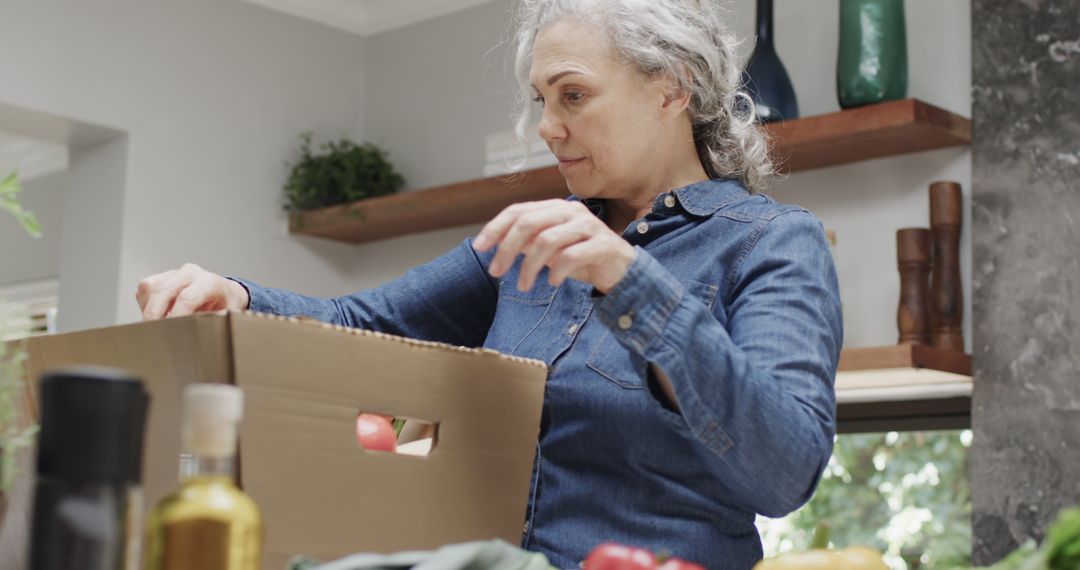 Senior Woman Unpacking Groceries in Cozy Kitchen - Free Images, Stock Photos and Pictures on Pikwizard.com