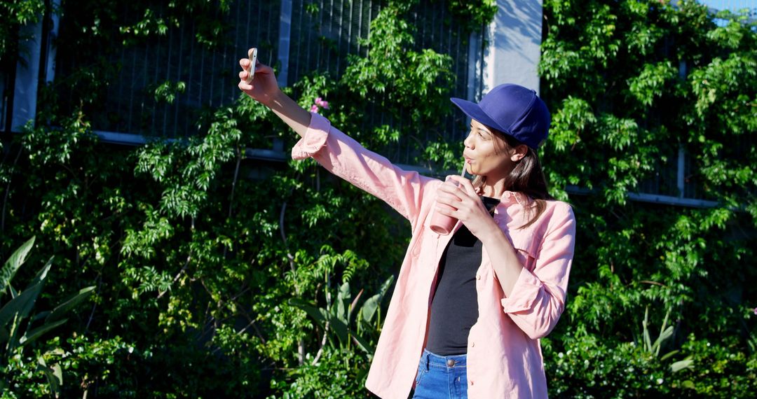 Young Woman in Pink Shirt Taking Selfie Outdoors on Sunny Day - Free Images, Stock Photos and Pictures on Pikwizard.com