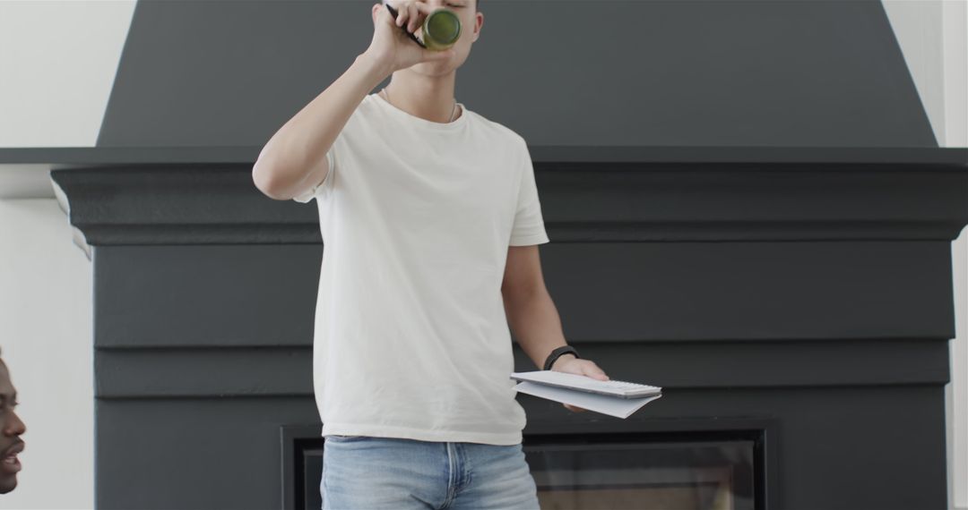 Confident Man Presenting with Notebook and Drink