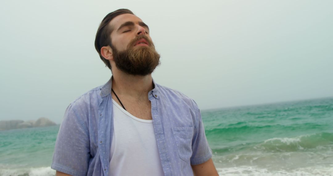 Young Man with Eyes Closed Enjoys Ocean Breeze