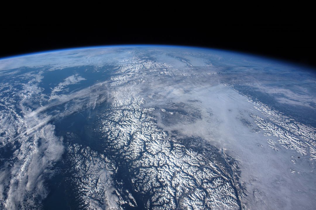 Earth from Space Showing Snow-Covered Mountains and Oceans Horizon - Free Images, Stock Photos and Pictures on Pikwizard.com