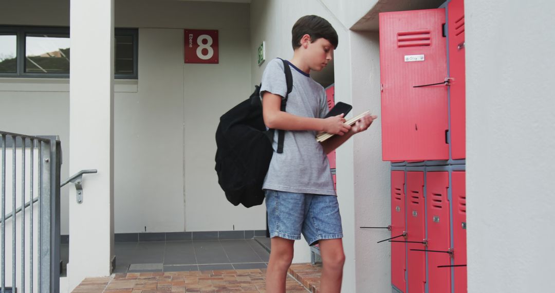 Young Student Organizing Books in School Locker Area