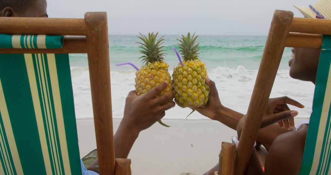 Couple Toasting Pineapple Drinks at Tropical Beach
