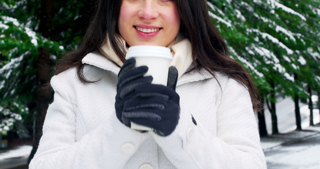 Woman in White Coat Holding Coffee Cup in Winter Forest - Free Images, Stock Photos and Pictures on Pikwizard.com