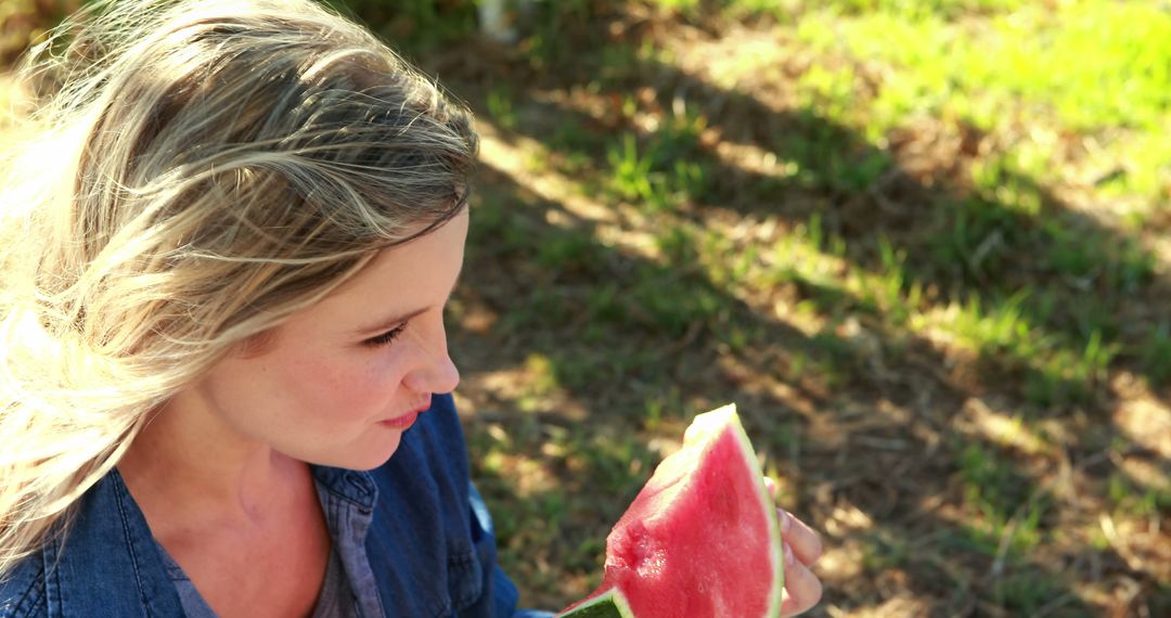 A young Caucasian girl enjoys a slice of watermelon outdoors, with copy space - Free Images, Stock Photos and Pictures on Pikwizard.com