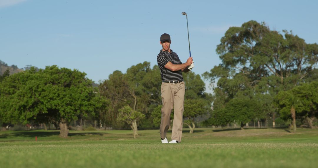 Focused Male Golfer in Action on Lush Green Golf Course - Free Images, Stock Photos and Pictures on Pikwizard.com