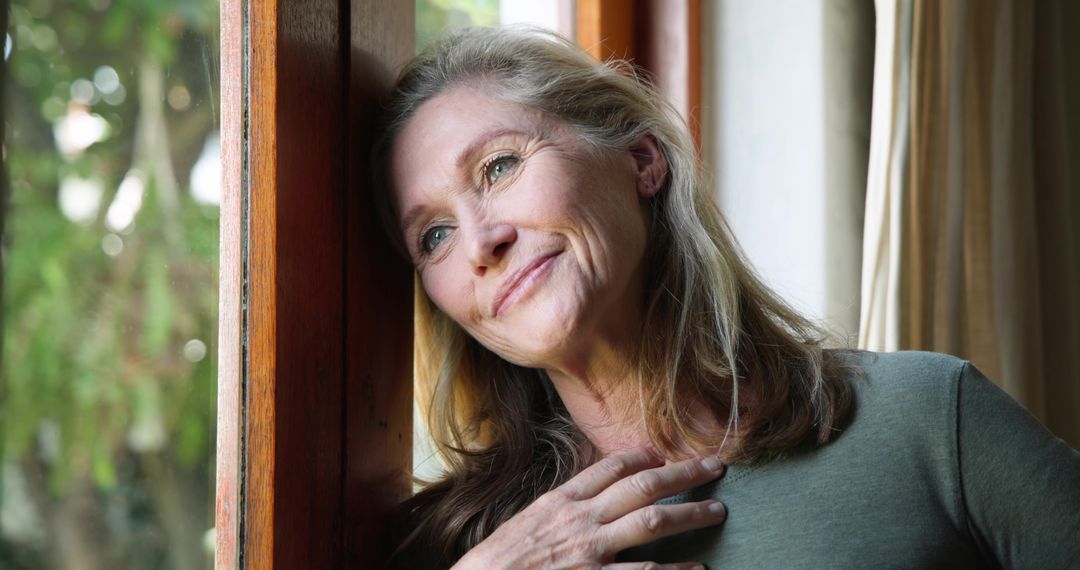 Senior Woman Contemplating Life by Window with Calm Demeanor