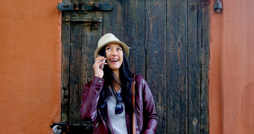 Happy Woman in Hat Talking on Phone Against Rustic Background - Free Images, Stock Photos and Pictures on Pikwizard.com