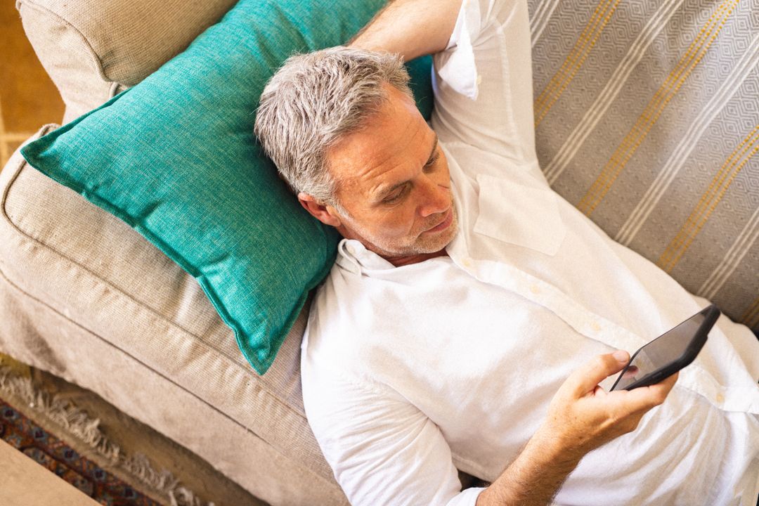 Caucasian Man Relaxing on Couch Using Smartphone - Free Images, Stock Photos and Pictures on Pikwizard.com
