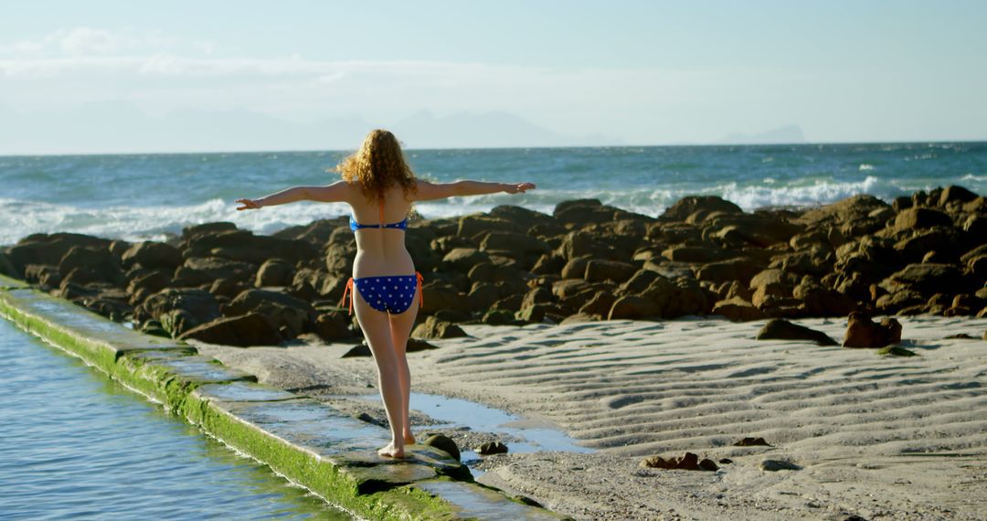 Woman in Bikini Enjoying Ocean View on Rocky Beach - Free Images, Stock Photos and Pictures on Pikwizard.com