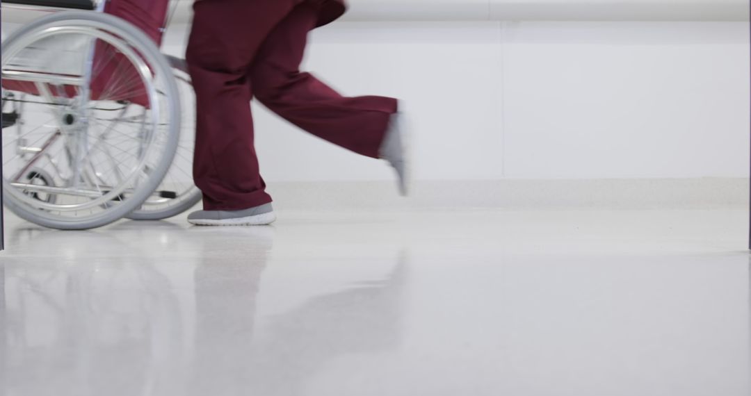 Healthcare Professional Pushing Wheelchair in Hospital Corridor - Free Images, Stock Photos and Pictures on Pikwizard.com