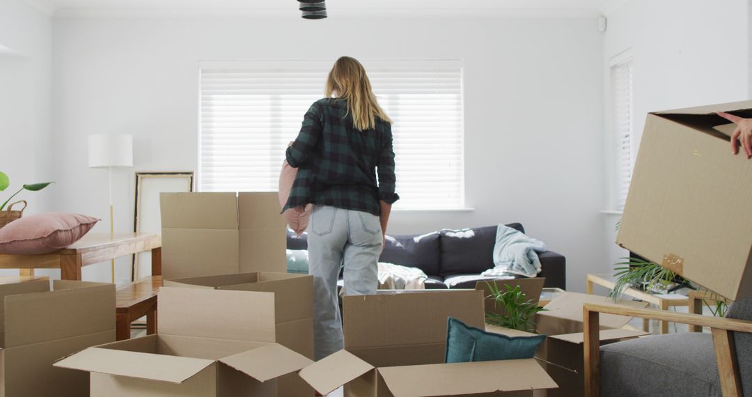 Young Woman Moving into New Home with Cardboard Boxes - Free Images, Stock Photos and Pictures on Pikwizard.com