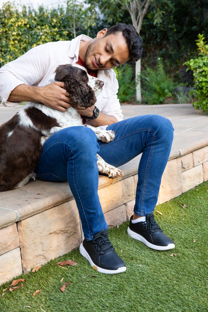 Man Bonding with Spaniel in Peaceful Backyard Setting