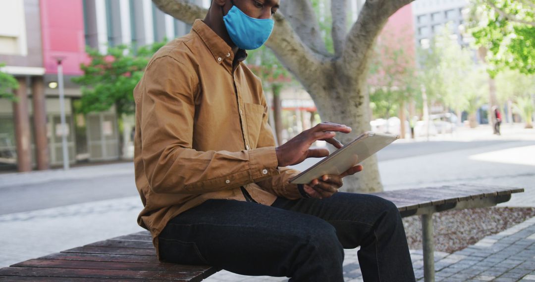 Young Man Wearing Face Mask Using Tablet in Public Park - Free Images, Stock Photos and Pictures on Pikwizard.com