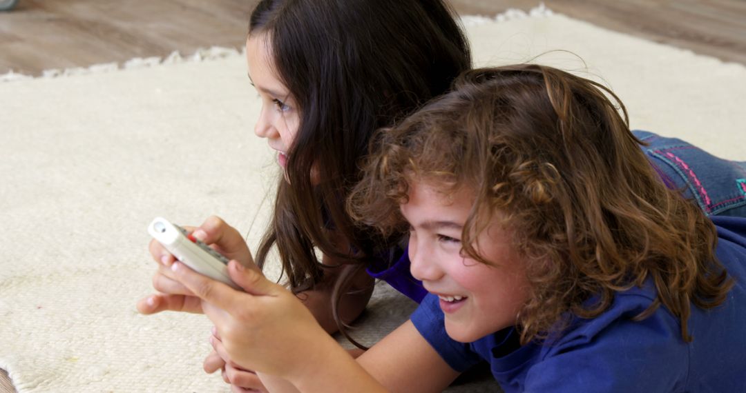 Children Using Remote Control While Lying on Carpet - Free Images, Stock Photos and Pictures on Pikwizard.com