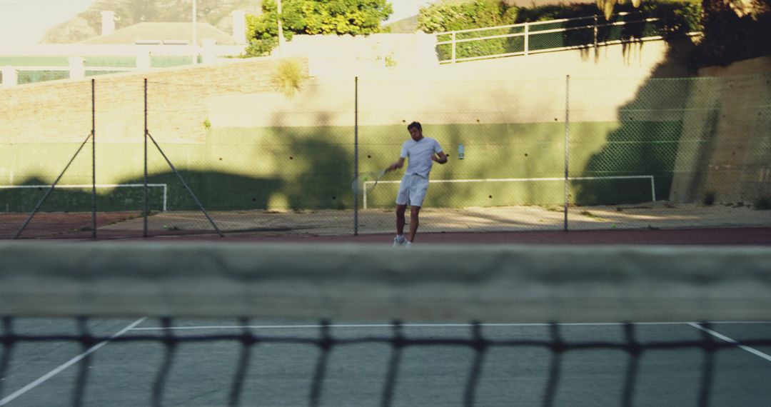 Man playing tennis on outdoor court in sunny weather - Free Images, Stock Photos and Pictures on Pikwizard.com