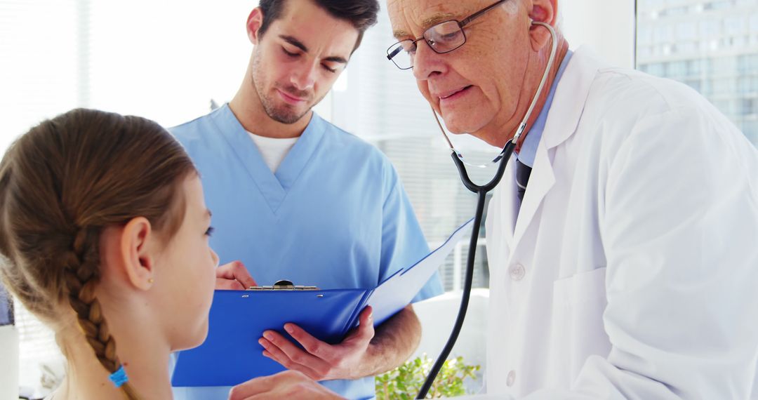 Senior Doctor Examining Young Patient with Nurse Taking Notes - Free Images, Stock Photos and Pictures on Pikwizard.com