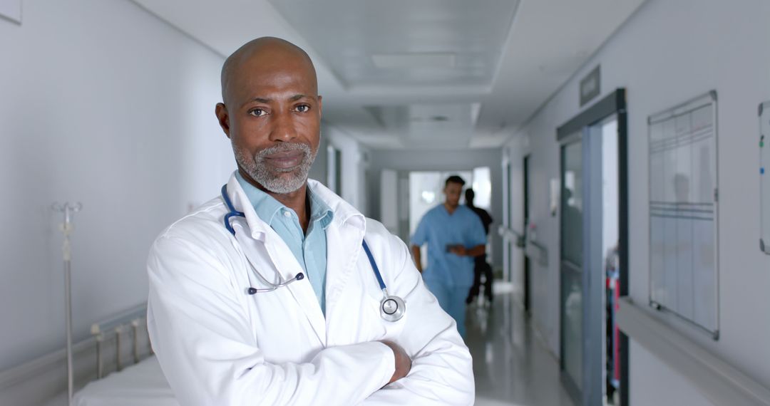 Confident Male Doctor in Hospital Corridor - Free Images, Stock Photos and Pictures on Pikwizard.com