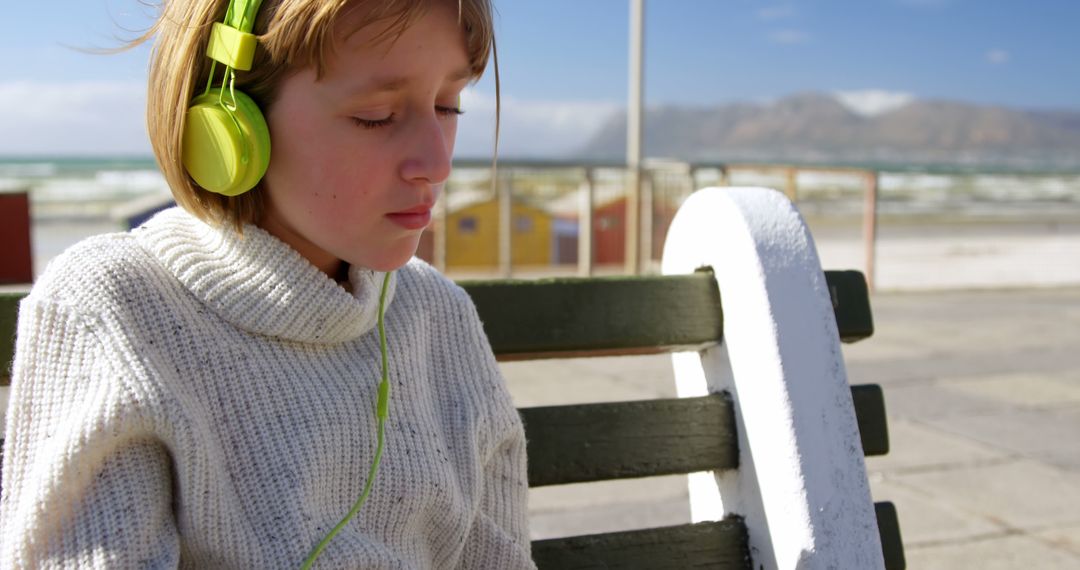 Child Listening to Music with Headphones Enjoying Beach View - Free Images, Stock Photos and Pictures on Pikwizard.com